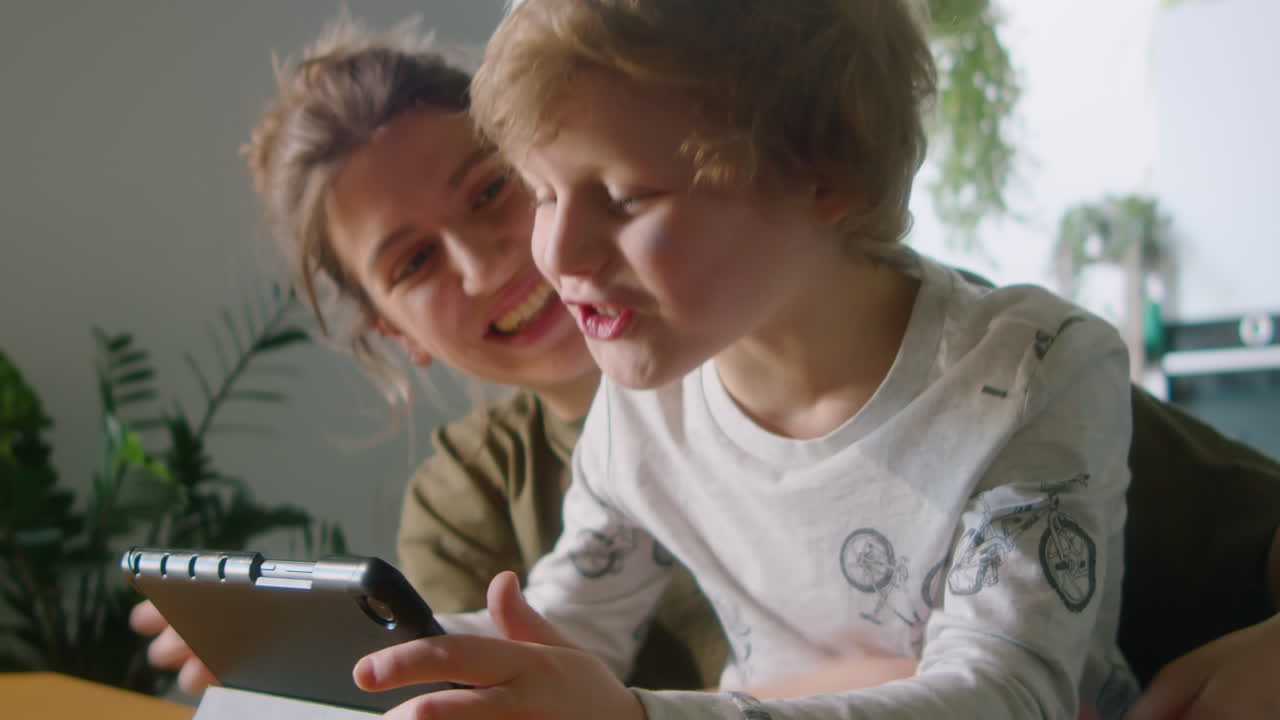 Excited Boy Playing on Digital Tablet with Mother at Home