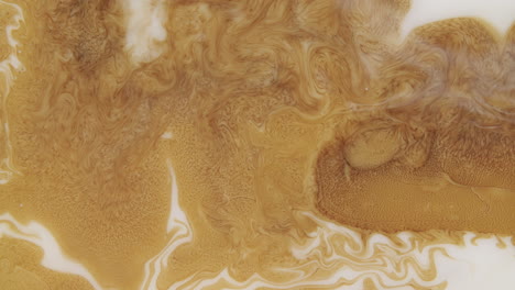 mesmerizing shot of a golden liquid forming abstract forms and patterns