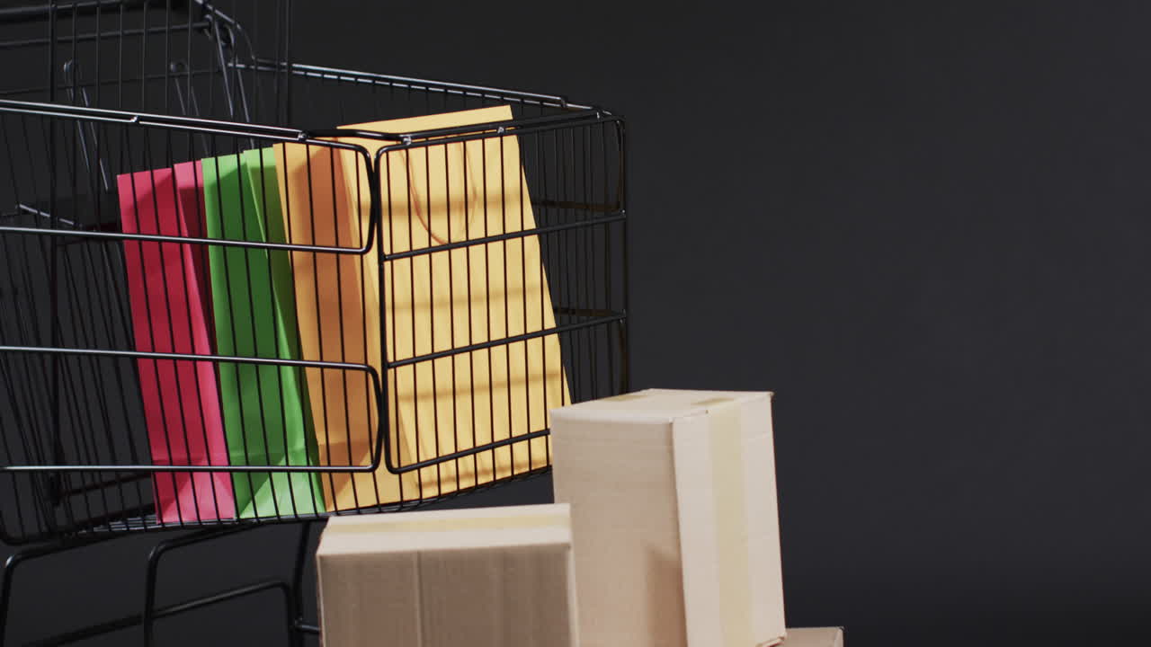 video de un carrito de compras y cajas con espacio de copia sobre un fondo gris