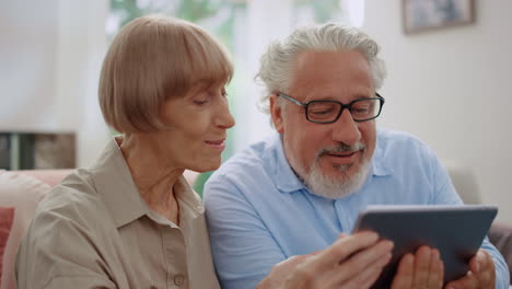 happy old couple using digital tablet