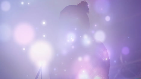 male singer performing on stage showcasing music production, with animated lens flares and haze