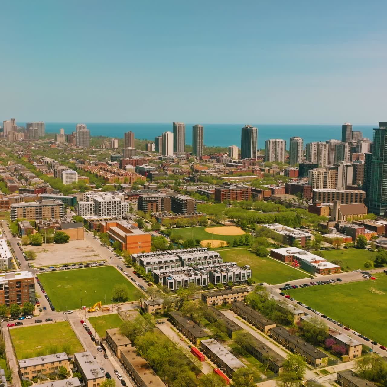 Scenic view of the residential area with low buildings and roads. Skyscrapers at backdrop against blue Michigan Lake