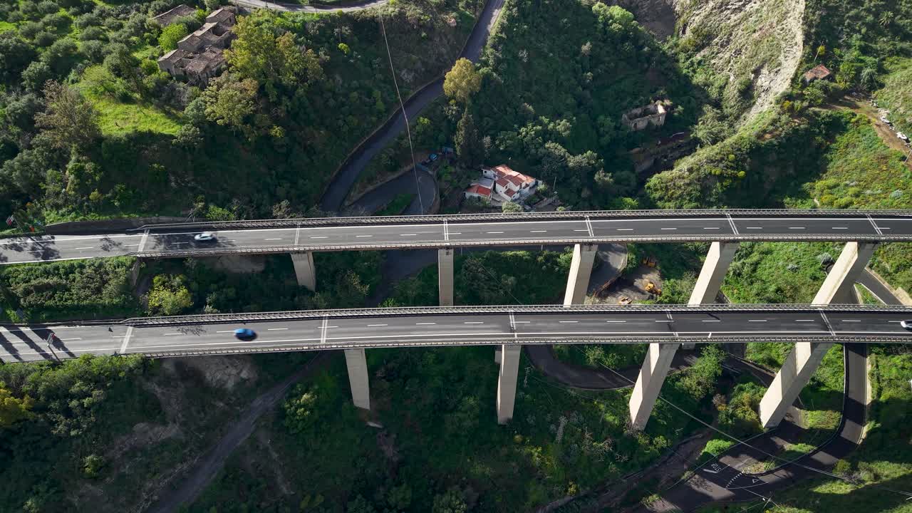 Ponte autostradale sopra una valle lussureggiante a Taormina, Sicilia