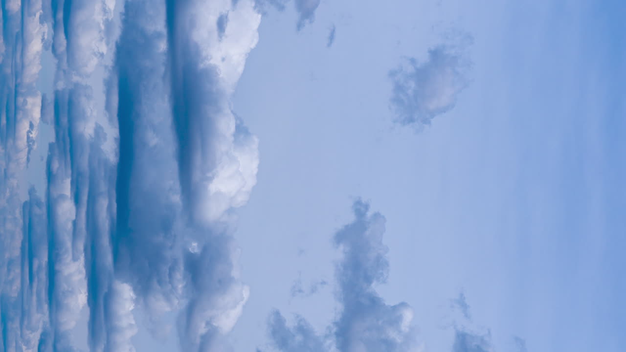 Nasty blue sky with cumulus clouds. Dramatic cloudscape in the atmosphere. Timelapse. Vertical screen.