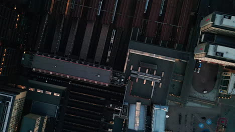 Oslo-aerial-view-over-train-station,-trains-are-lining-in-railway-tracks,-captured-with-low-angle-sunlight,-urbanization-and-transportation-concept