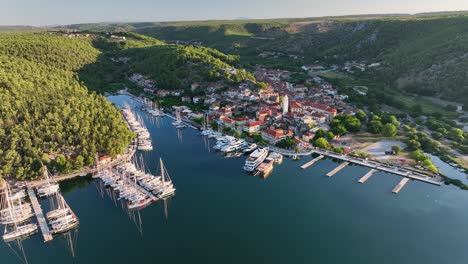 video aéreo de un avión no tripulado volando hacia el casco antiguo de skradin en croacia desde lejos, descendiendo lentamente