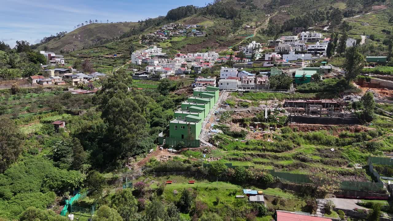Fog draping over distant ridges with scattered homes creating a moody atmosphere