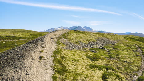 green valley surrounded with the peaks of rondane national park in norway