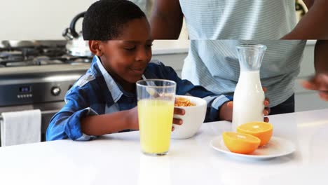 Padre-Vertiendo-Leche-En-Cereales-Para-Hijos-En-La-Cocina