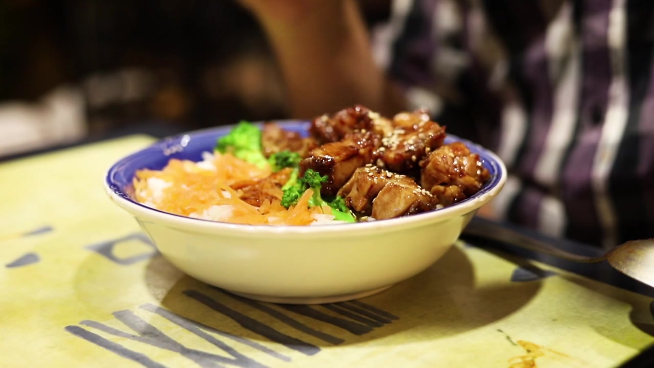 Mencampur semangkuk makanan Jepang dengan nasi putih dan ayam teriyaki di restoran Jepang