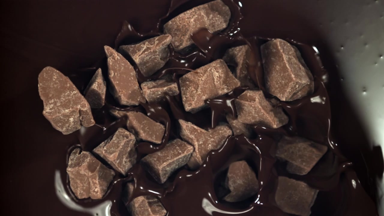 Cioccolato fuso che ricopre pezzi di cioccolato al super rallentatore