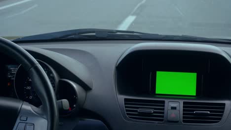 inside a car. a gps module is on. green screen