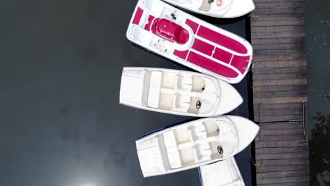 vista de pequeños botes de motor vacíos atracados junto a una plataforma de madera