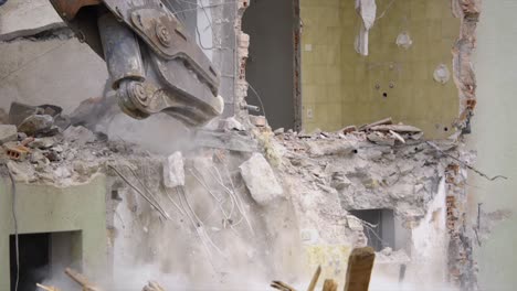 demolition of a building with bulldozer arm slow motion