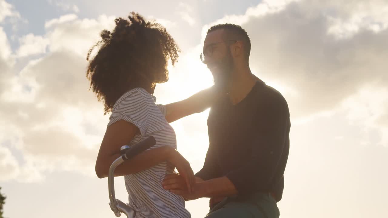pareja besándose en ciclo en la playa 4k