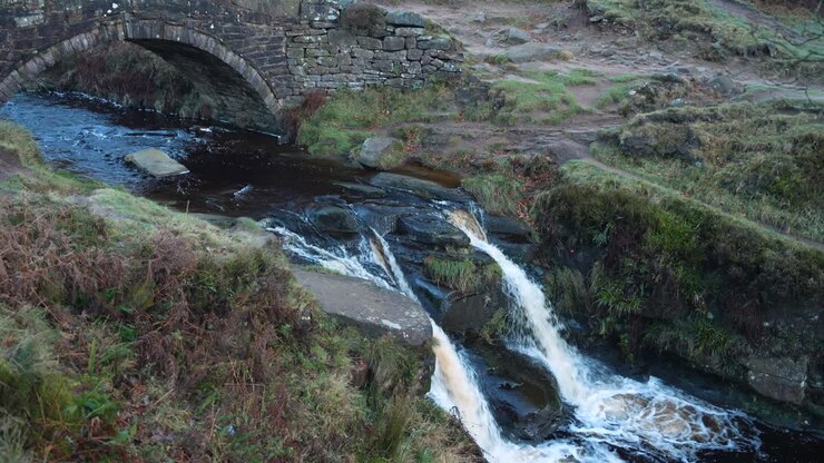 Stone bridge over river and waterfall