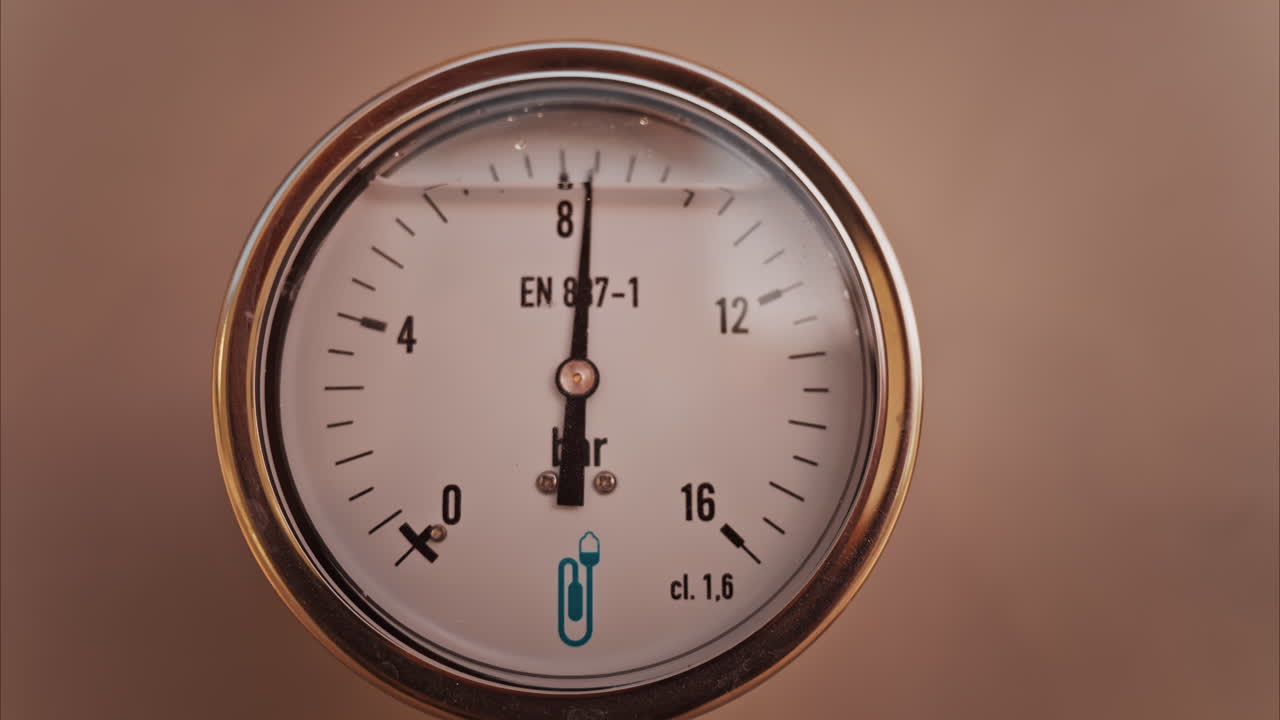 Close up of a circular pressure gauge with a metallic frame indicating the current pressure is 8 bar