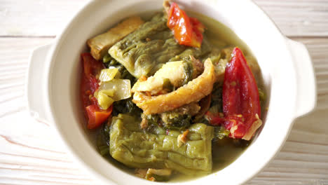 sopa de calabaza amarga y verde mostaza en conserva con carne de cerdo