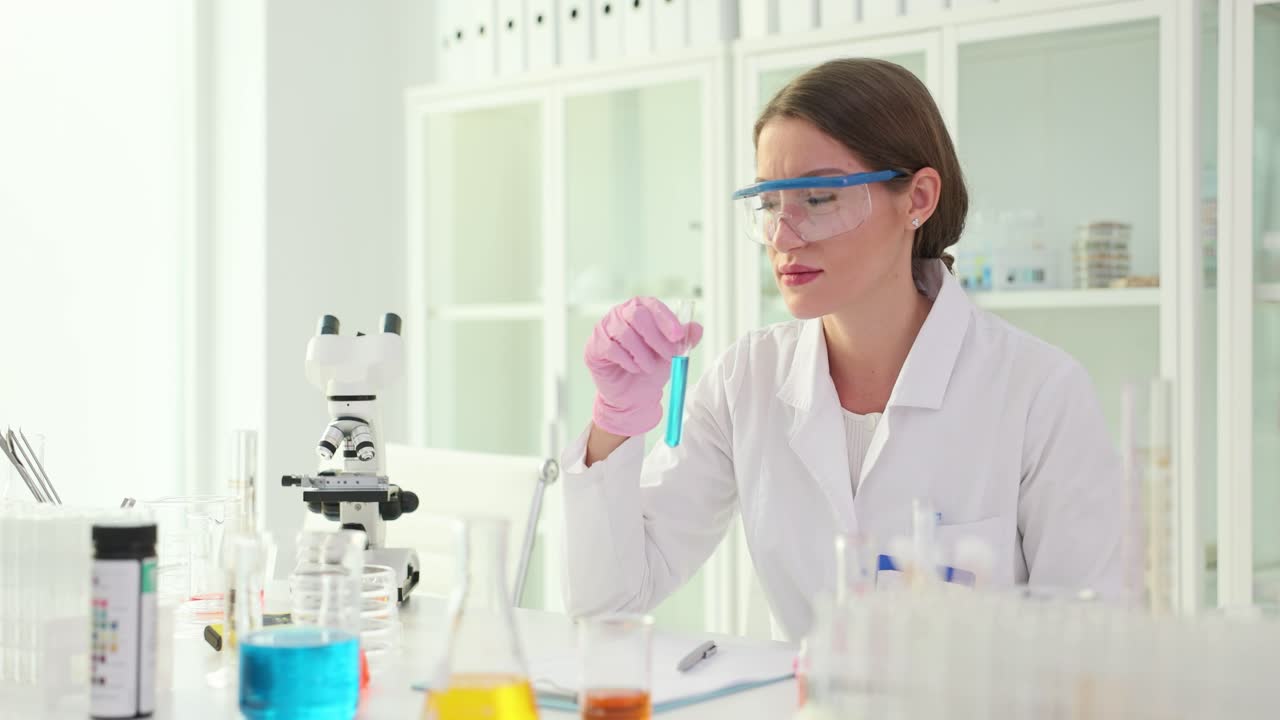 Female Scientist Examining Blue Liquid in a Test Tube in a Laboratory