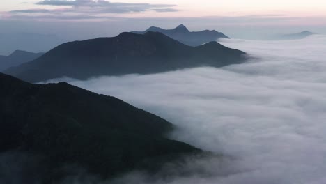 在中國香港的kowloon peak的藍色時間, 密集的雲層在山頂之間通過的空中偏差