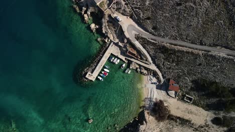 Tiro-Abajo-Ojo-De-Pájaro-Con-Drone-En-Luka-Croacia-Costa-Mar-Claro-Y-Puerto-Con-Barcos-Vista-Majestuosa