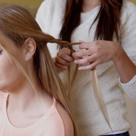 bella donna con un amico che le aggiusta i capelli biondi