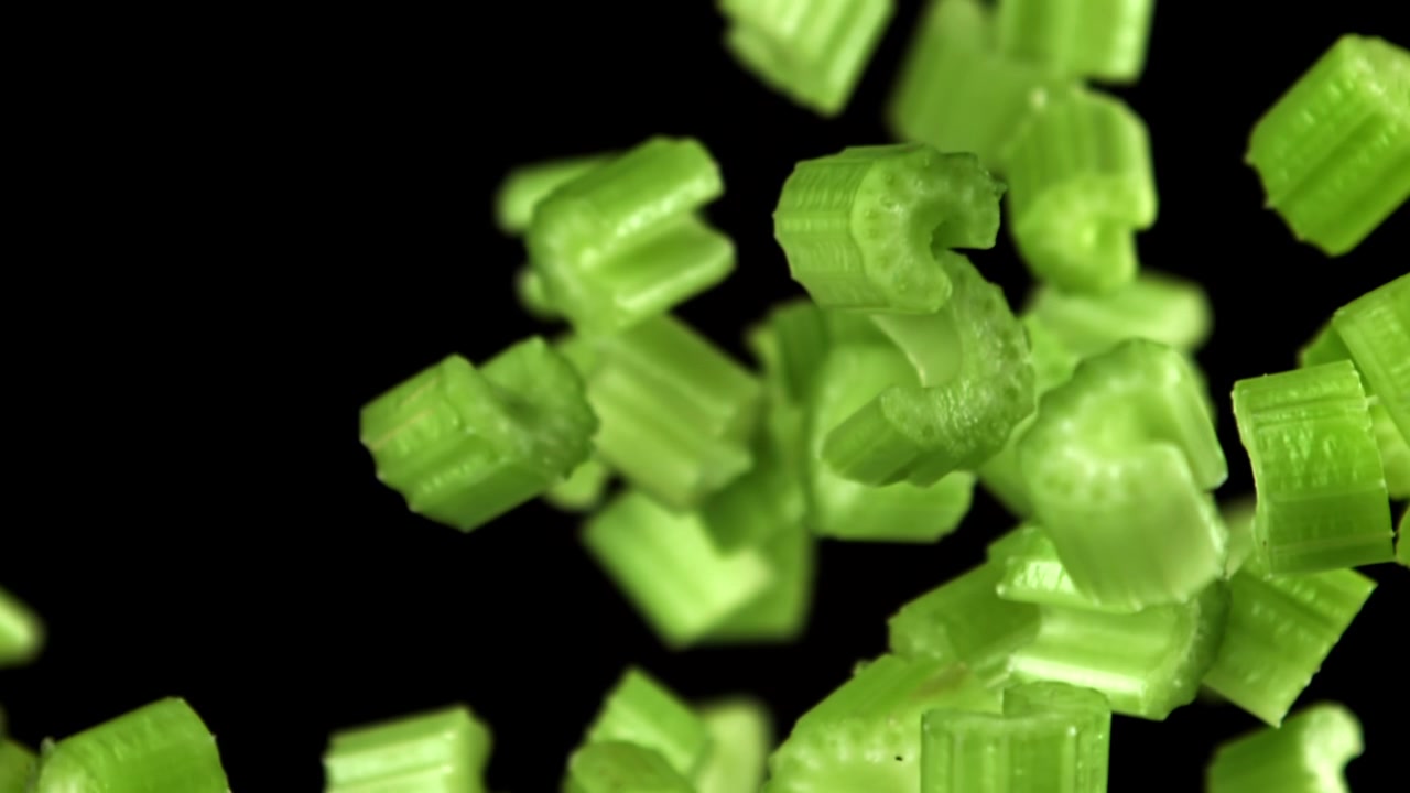 Chopped Green Celery Pieces Falling in Slow Motion
