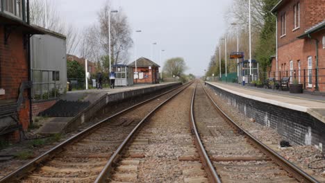 Teenagers-walking-through-old-village-railway-station-in-England