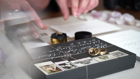 arranging wedding invitations, rings, planner and stationary for display