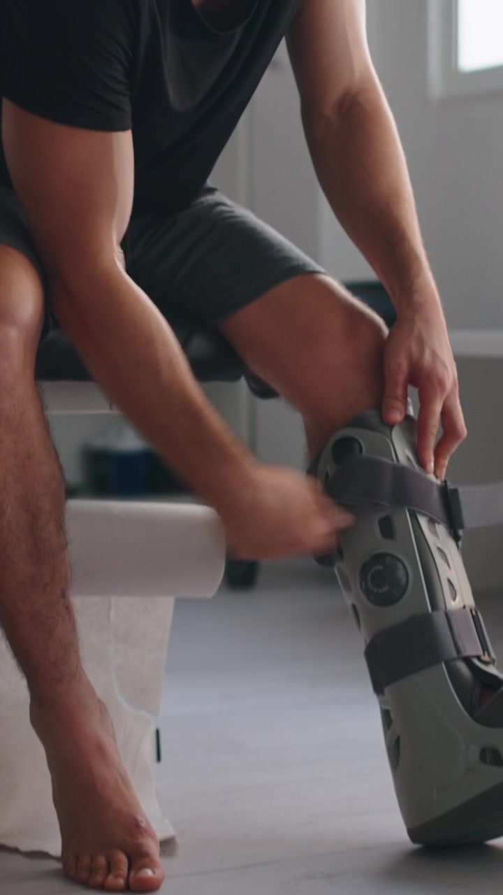 Man Removing Orthopedic Walking Boot After Injury
