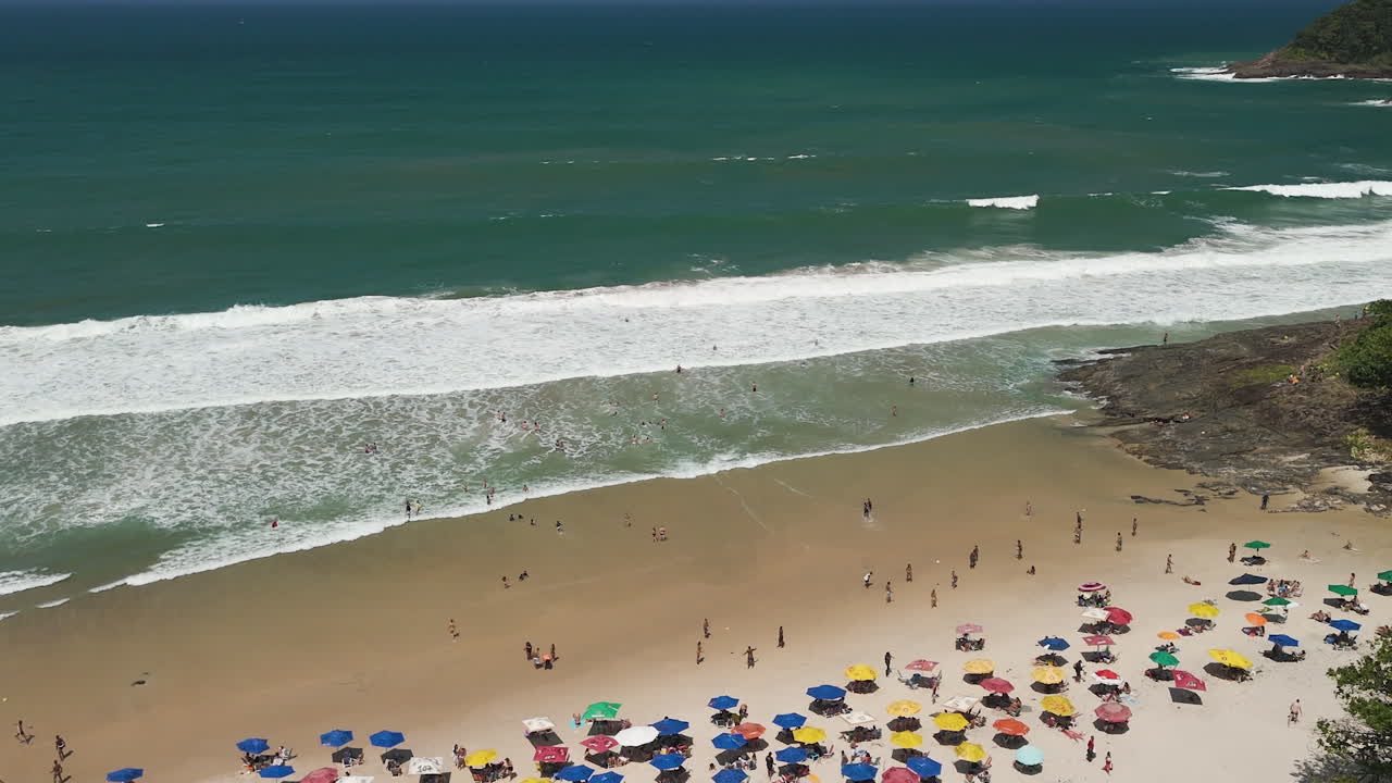 Vista Aérea de Praia Lotada com Guarda-sóis Coloridos