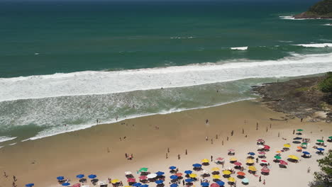 aerial view of crowded beach with colorful umbrellas