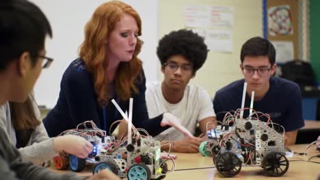 enthusiastic teacher guides students in a robotics workshop, where they build and program robotic vehicles together. collaboration fosters innovation and problem-solving skills.
