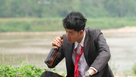 business man depressed by river