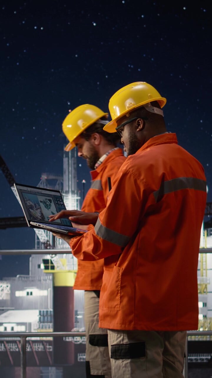 Vertical video Offshore platform workers using map on laptop to circumvent extraction embargo