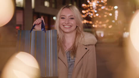 young attractive woman shows off her recent purchase from shopping trip and smiles