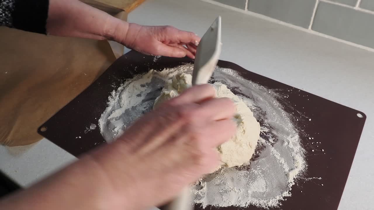 Mani di donna che modellano l'impasto del pane in una palla.