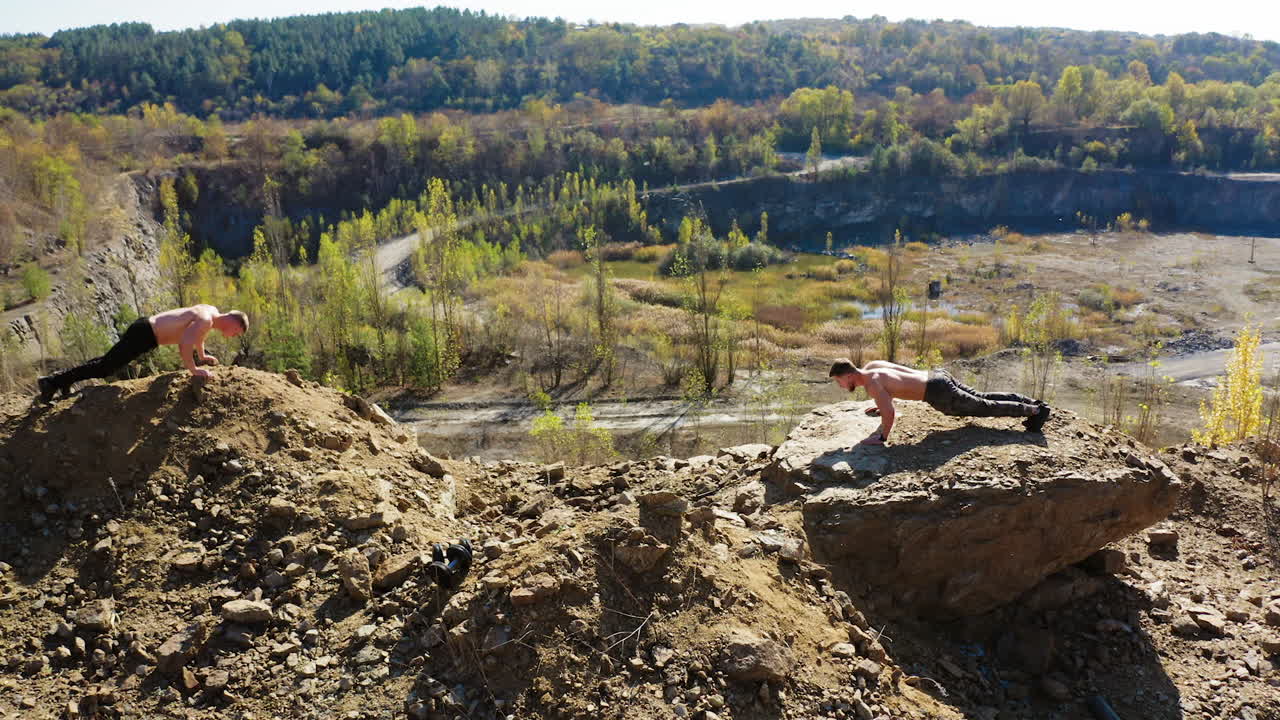 Sportsmen doing push ups. Aerial view of young athletes doing push ups outdoors
