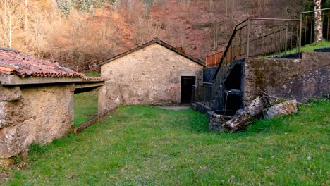 POV-Walking-Back-Along-Grass-In-With-Abandoned-Rustic-Water-Mill-Building-With-Old-Traditional-Clay-Roofing-Tiles