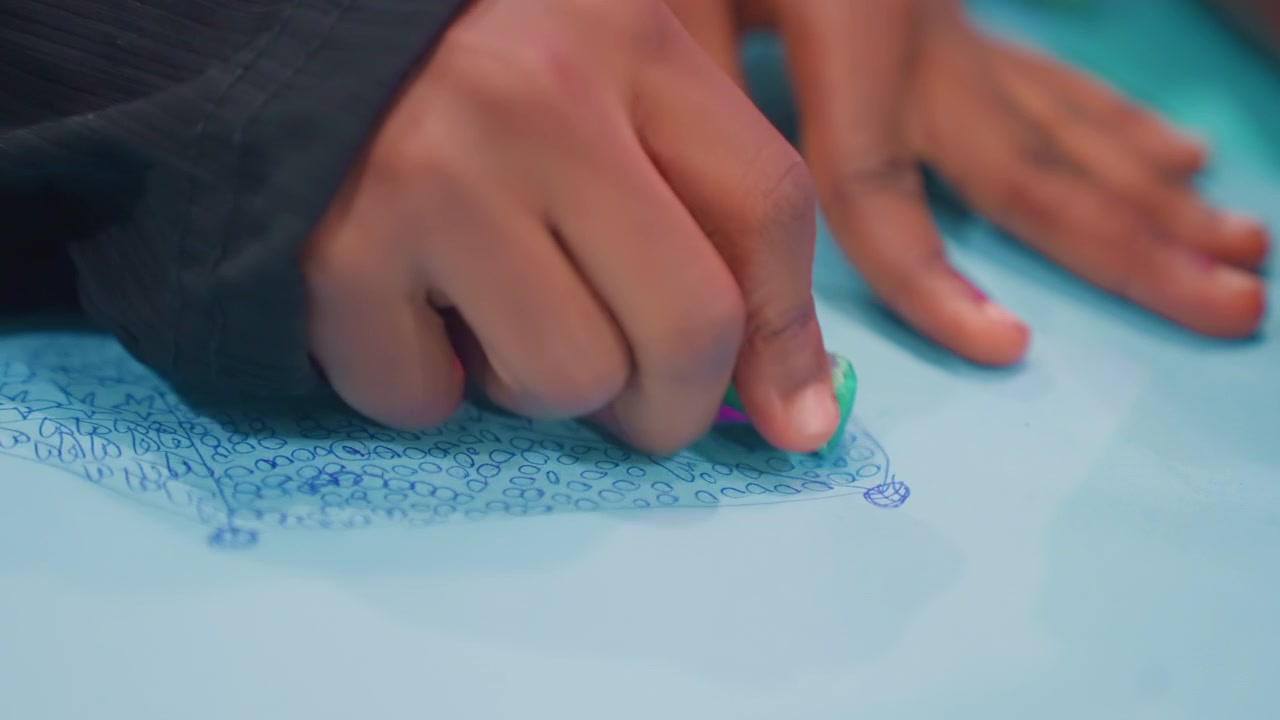 Child sketching with pastel crayons. Little kid drawing on soft paper with focus. Young child passionately practicing art using green crayon on gentle pastel paper in cozy indoor space