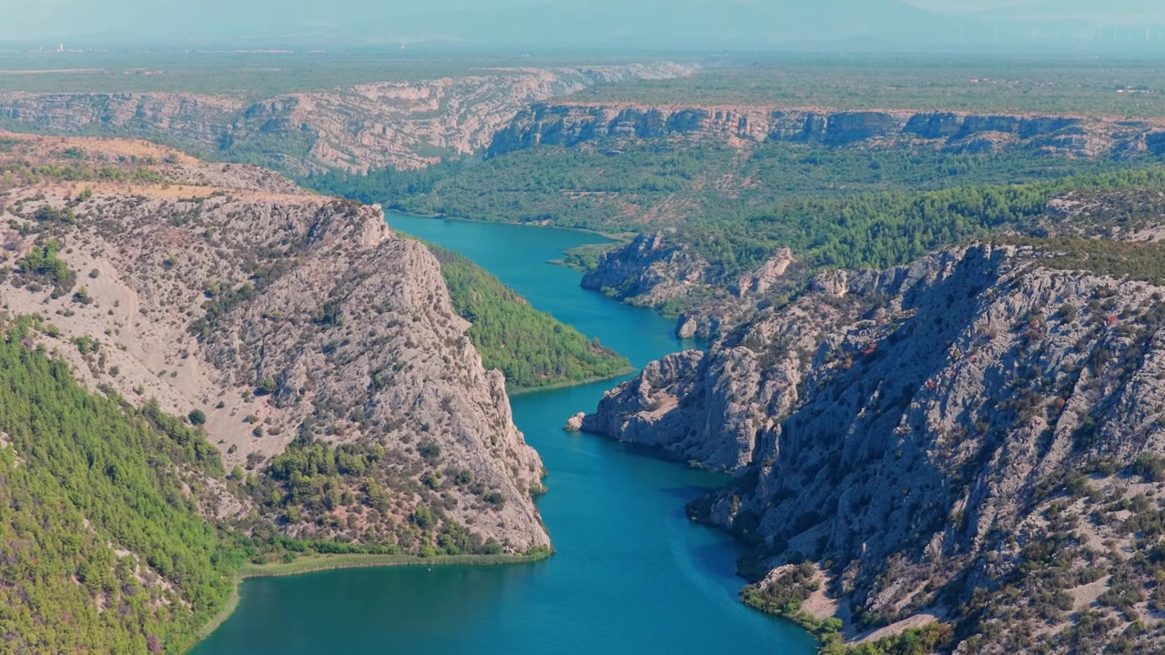 Ripresa con drone del Canyon Među Gredama nel Parco Nazionale di Cherca, che rivela scogliere aspre, vegetazione rigogliosa e un tortuoso fiume turchese sotto cieli luminosi