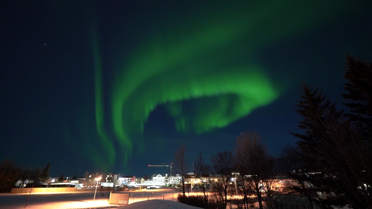 Timelapse of incredible green glowing northern lights dancing and swirling through the dark, night sky in Iceland over Selfoss
