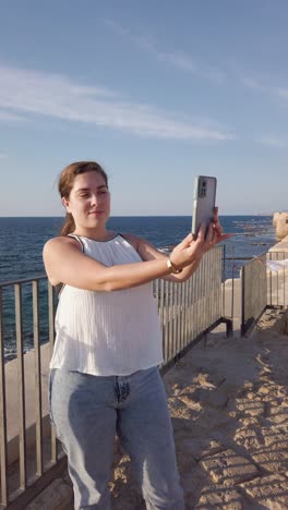 tourist woman taking a photo in old acre, israel.