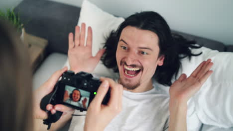 couple taking photos in bed