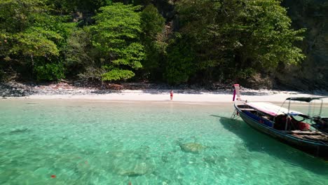 Drone-Aéreo-De-Un-Joven-Turista-Masculino-En-Pantalones-Cortos-Naranjas-Abandonado-En-Una-Playa-De-Isla-Paradisíaca-En-Medio-De-La-Isla-Ko-Kai-En-Krabi-Tailandia-Rodeada-De-Hermosas-Aguas-Azul-Turquesa