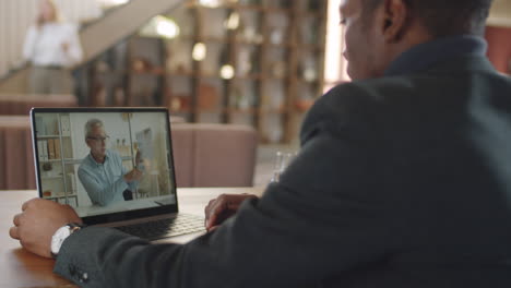 Black Businessman Talking on Video Call in Restaurant