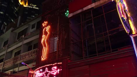 señales de neón parpadeando en un edificio de altura por la noche