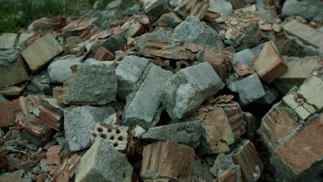 a pile of old broken bricks with tall grass next to it