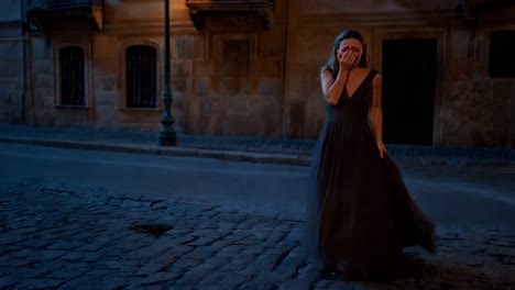 crying woman in old city street at night