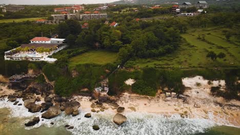 Beautiful-Bingin-beach-with-exotic-cliffs-houses-and-hotel-located-in-Bali,-Indonesia